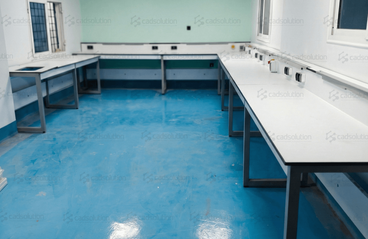 Aménagement laboratoire Biskra avec paillasses murales blanches et sol en résine bleue.